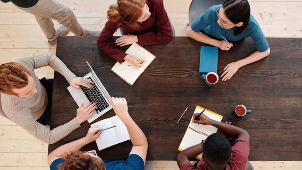 personnes travaillant sur ordinateurs autour d une table